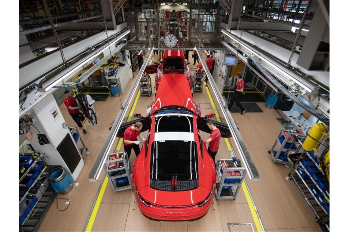 Mitarbeiter der Porsche AG montieren im Hauptwerk einen Porsche 911. Foto: Marijan Murat/dpa