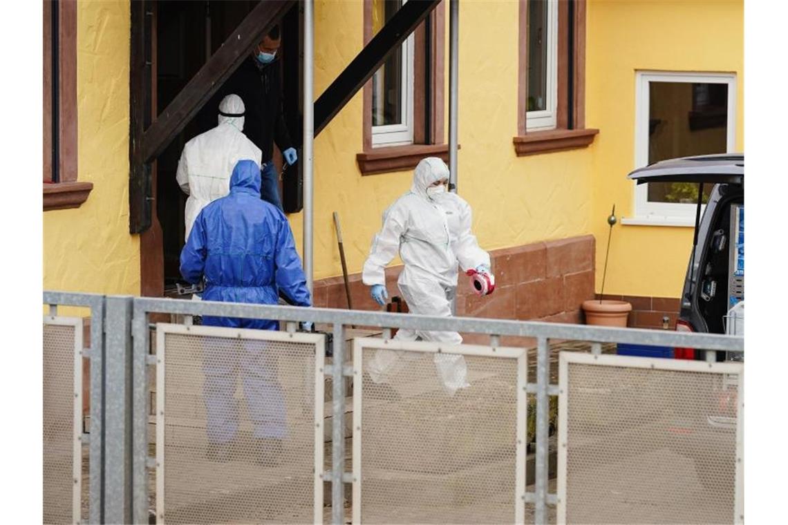 Mitarbeiter der Spurensicherung auf einem Anwesen in Weilerbach. Foto: Uwe Anspach/dpa