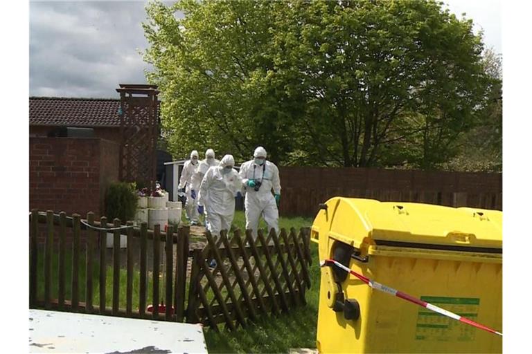 Mitarbeiter der Spurensicherung gehen durch den Garten des Wohnhauses, in dem eine 35-jährige Frau und ihr 4-jähriger Sohn tot aufgefunden wurden. Foto: -/TNN/dpa