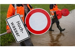 Mitarbeiter der Stadt Riedlingen in Baden-Württemberg stellen am 31. Mai Absperr- und Hinweisschilder mit der Aufschrift „Hochwasser“an einem vom Regen überfluteten Radweg auf.