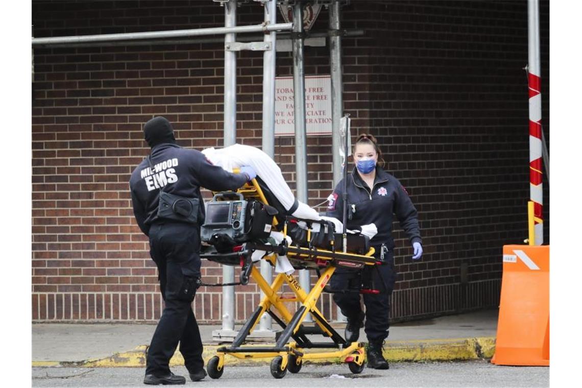 Mitarbeiter des Gesundheitswesens schieben einen Patienten in das Brooklyn Hospital Center in Brooklyn. In der außer Kontrolle geratenen Corona-Pandemie in den USA könnten in den kommenden Monaten nach Modellrechnungen weitere Zehntausende Menschen sterben. Foto: Wang Ying/XinHua/dpa
