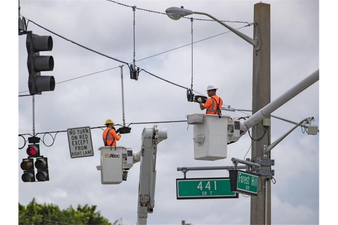 Mitarbeiter des Palm Beach County im Süden des US-Bundesstaats Florida installieren Ampeln, die vor der Ankunft des Hurrikans vorsorglich demontiert worden waren. Foto: Allen Eyestone/Palm Beach Post via ZUMA Wire