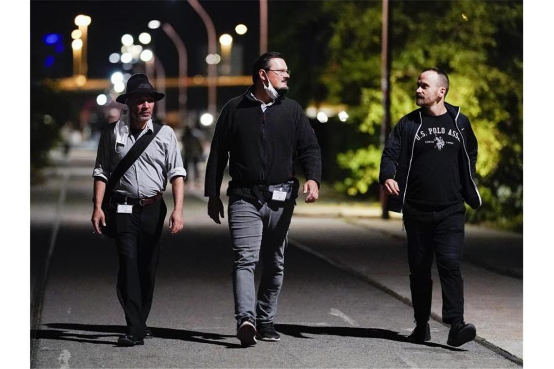 Mitarbeiter des Projekts „Nachtschicht“ gehen im Stadtteil Jungbusch über einen Weg. Foto: Uwe Anspach/dpa