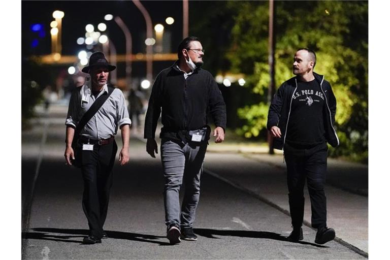 Mitarbeiter des Projekts „Nachtschicht“ gehen im Stadtteil Jungbusch über einen Weg. Foto: Uwe Anspach/dpa