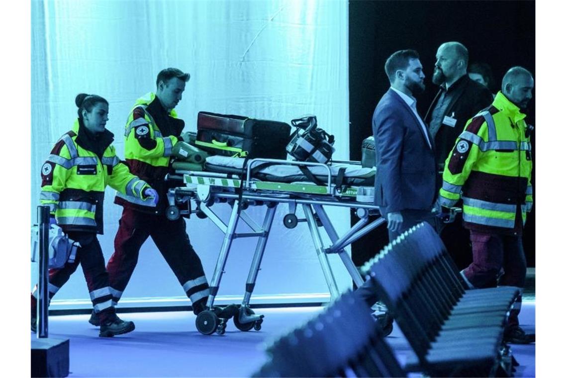 Mitarbeiter des Rettungsdienstes auf dem Weg in die Dortmunder Westfalenhalle, wo Wirtschaftsminister Peter Altmaier schwer gestürzt ist. Foto: Bernd Thissen/dpa