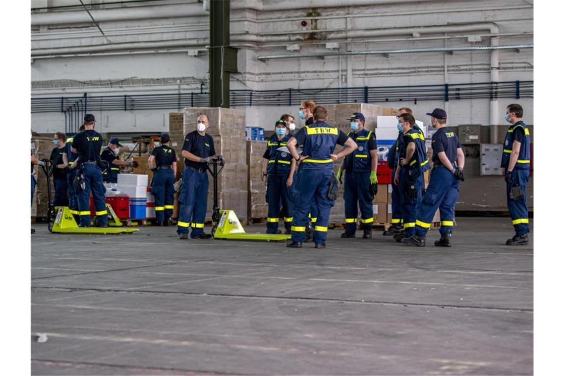 Mitarbeiter des Technischen Hilfswerks richten ein Corona-Testzentrum auf dem Gelände des ehemaligen Militärflughafens in Gütersloh ein. Foto: David Inderlied/dpa