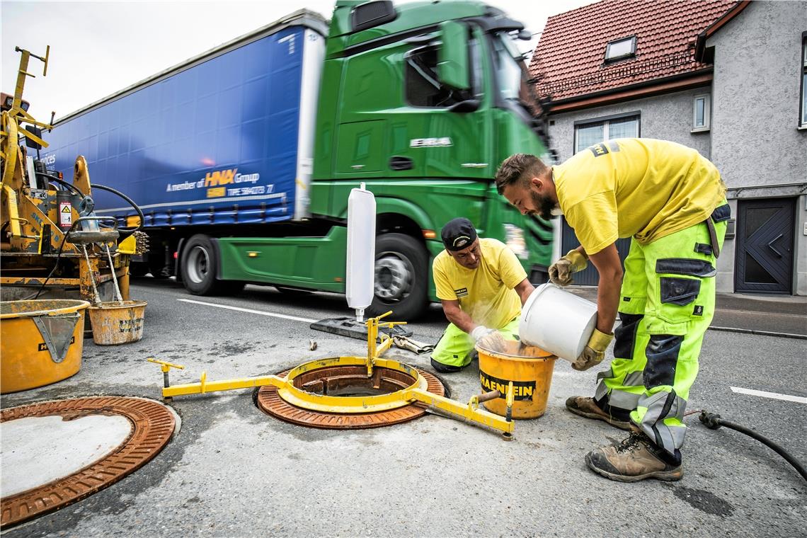 Tempo 30 und neue Schachtdeckel Mitarbeiter einer Firma aus München bauen neue Schachtdeckel auf der B14 in Oppenweiler ein. Wenn ein Auto oder ein Lastwagen darüber fährt, sollen sie weniger Lärm machen als die alten.Foto: A. Becher
