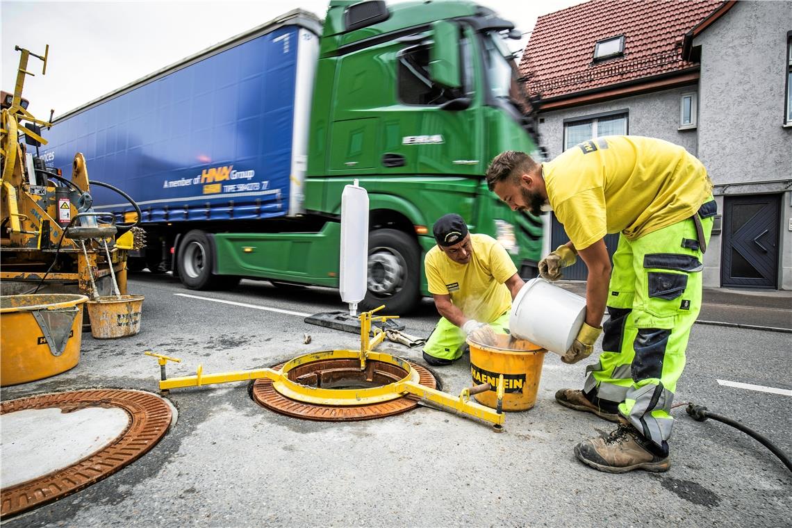 Mitarbeiter einer Firma aus München bauen neue Schachtdeckel auf der B14 in Oppenweiler ein. Wenn ein Auto oder ein Lastwagen darüber fährt, sollen sie weniger Lärm machen als die alten.Foto: A. Becher