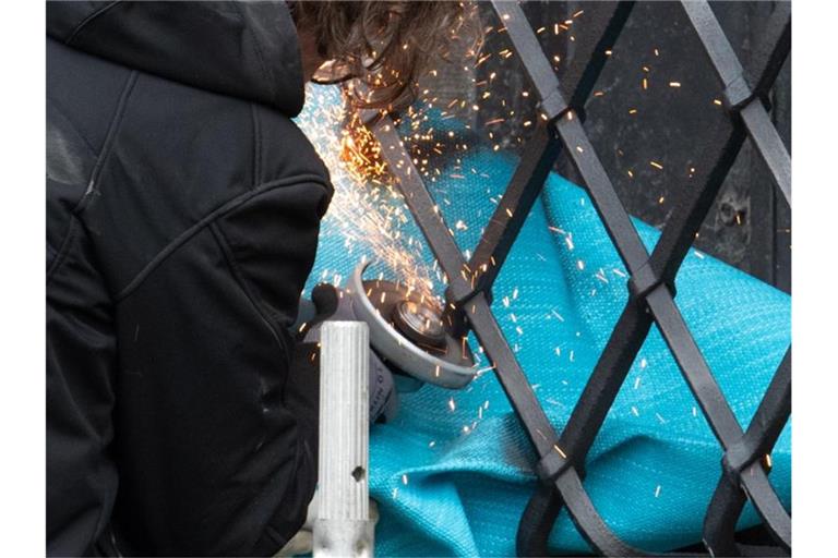 Mitarbeiter einer Restaurierungsfirma arbeiten mit einem Winkelschleifer am durchtrennten Gitterfenster des Grünen Gewölbes. Foto: Robert Michael/dpa-Zentralbild/dpa