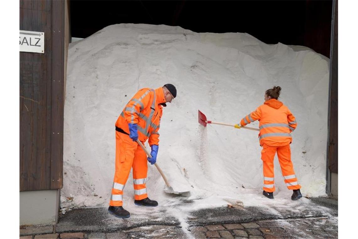 Mitarbeiter einer Stadtreinigung schaufeln Salz im Salzlager. Foto: Marcus Brandt/dpa/Archivbild