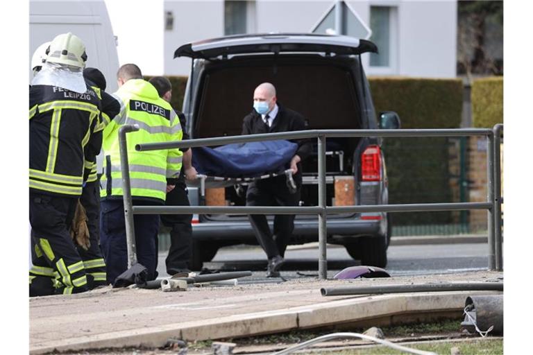 Mitarbeiter eines Bestattungsunternehmens tragen ein Opfer zu einem Leichenwagen. Foto: Jan Woitas/dpa-Zentralbild/dpa