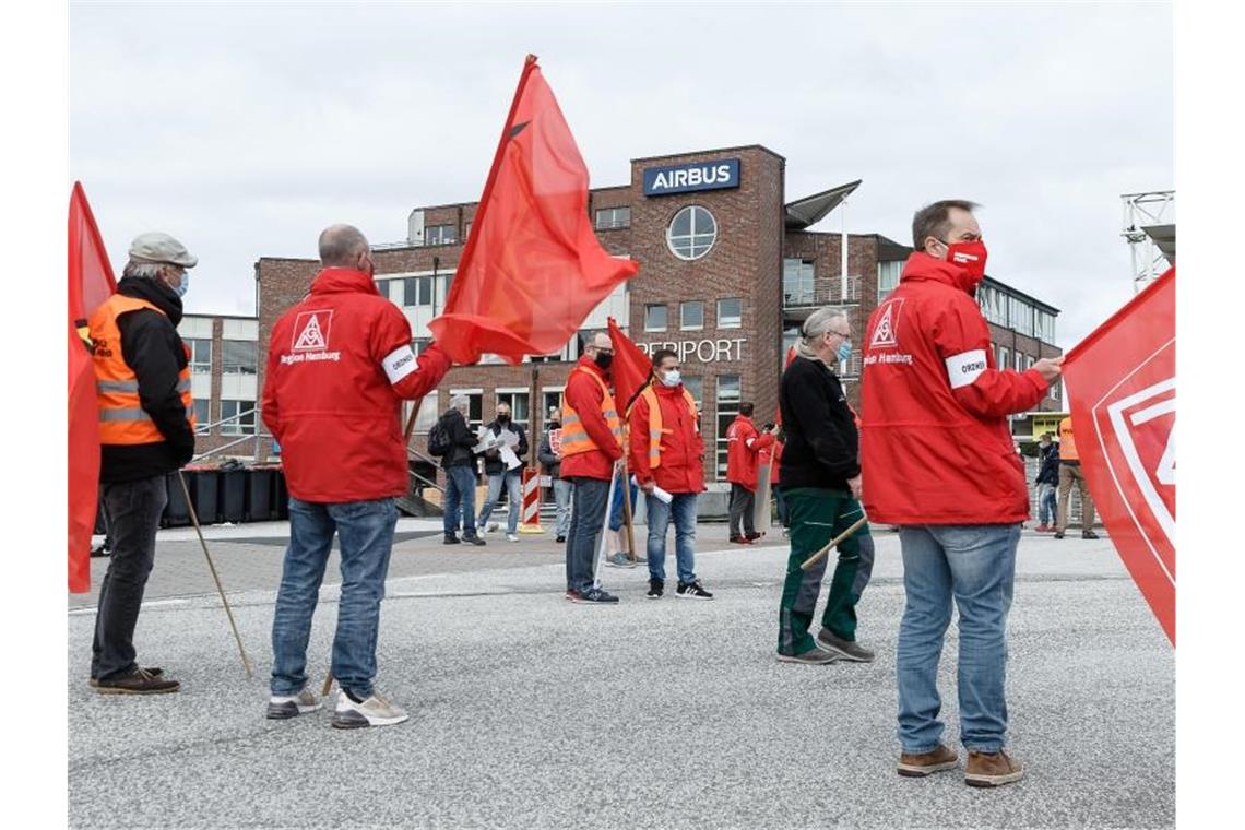 Mitarbeiter im Warnstreik vor dem Haupteingang von Airbus in Hamburg-Finkenwerder. Foto: Markus Scholz/dpa