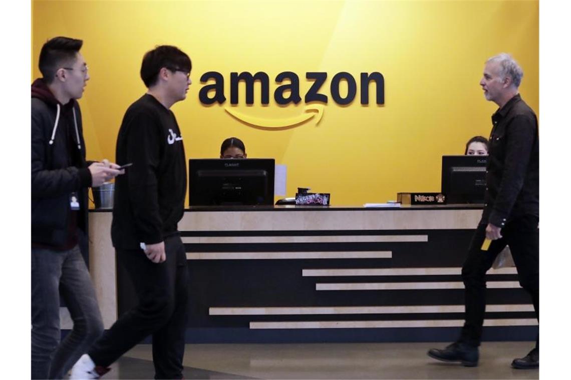 Mitarbeiter in der Lobby der Amazon-Zentrale in Seattle. Foto: Elaine Thompson/AP/dpa