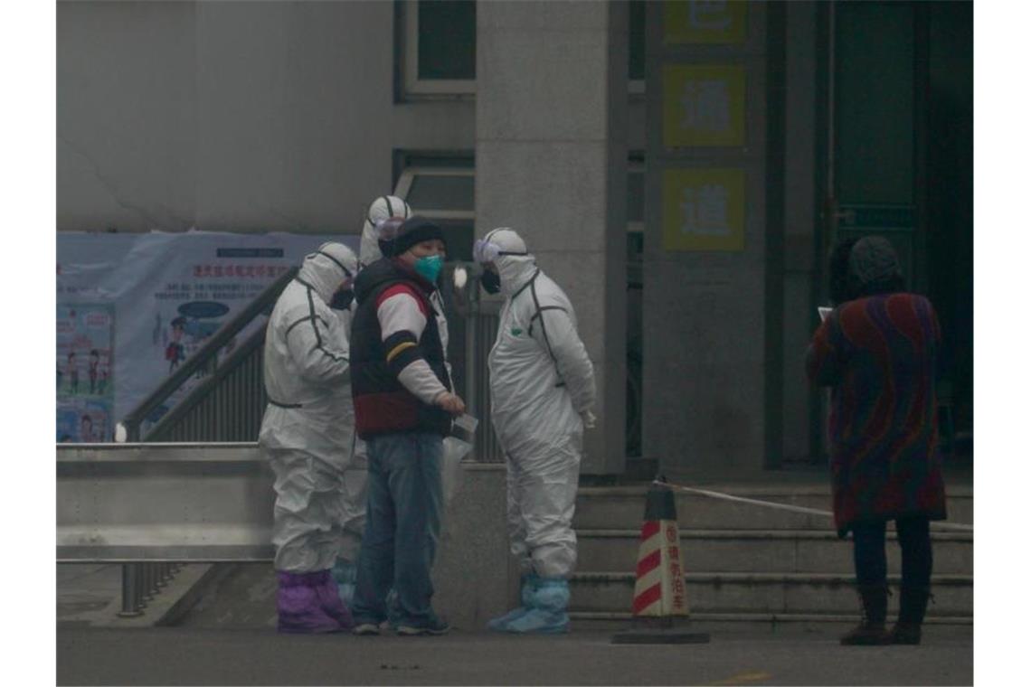 Mitarbeiter in Schutzanzügen vor dem Wuhan Medical Treatment Center in Wuhan, in dem ein Patient mit Verdacht auf den neuartigen Corona-Virus behandelt wurde. Foto: Dake Kang/AP/dpa
