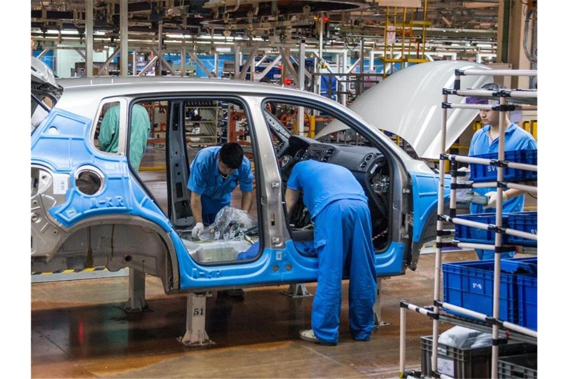 Mitarbeiter montieren im Werk der Volkswagen AG in Anting bei Shanghai einen VW Tiguan. Foto: Ole Spata/dpa