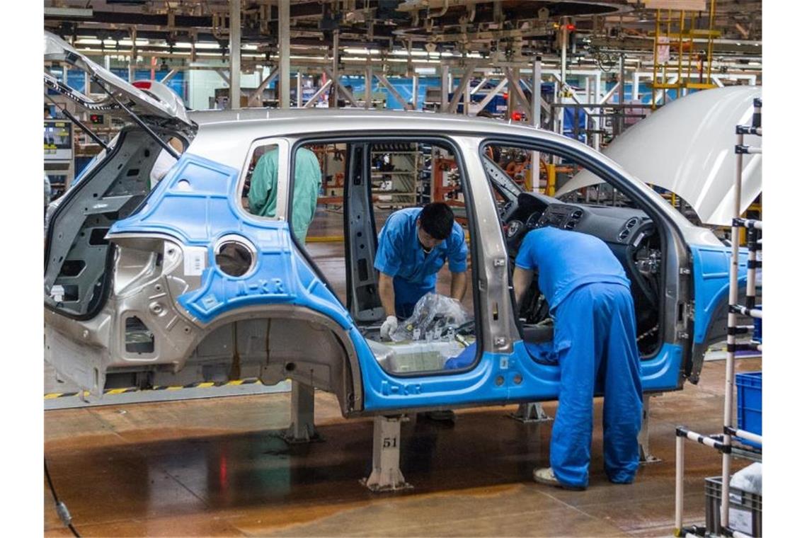 Mitarbeiter montieren im Werk der Volkswagen AG in Anting bei Shanghai einen VW Tiguan. Foto: Ole Spata/dpa