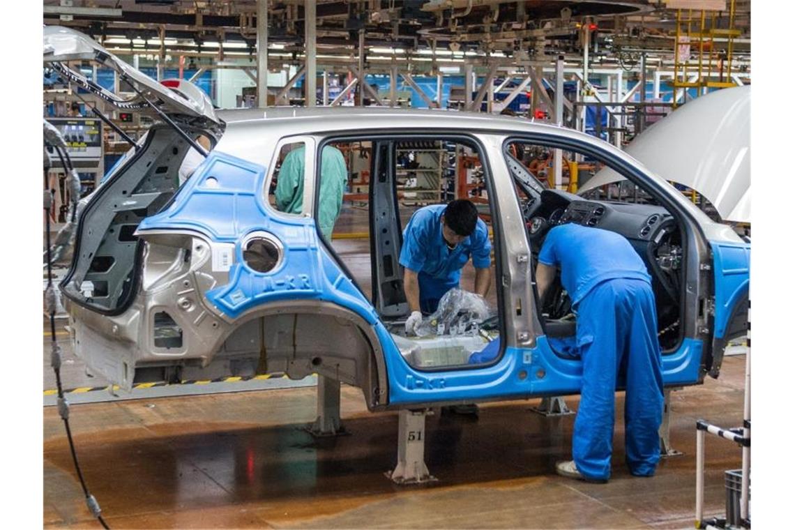 Mitarbeiter montieren im Werk der Volkswagen AG in Anting bei Shanghai einen VW Tiguan. Foto: Ole Spata/dpa
