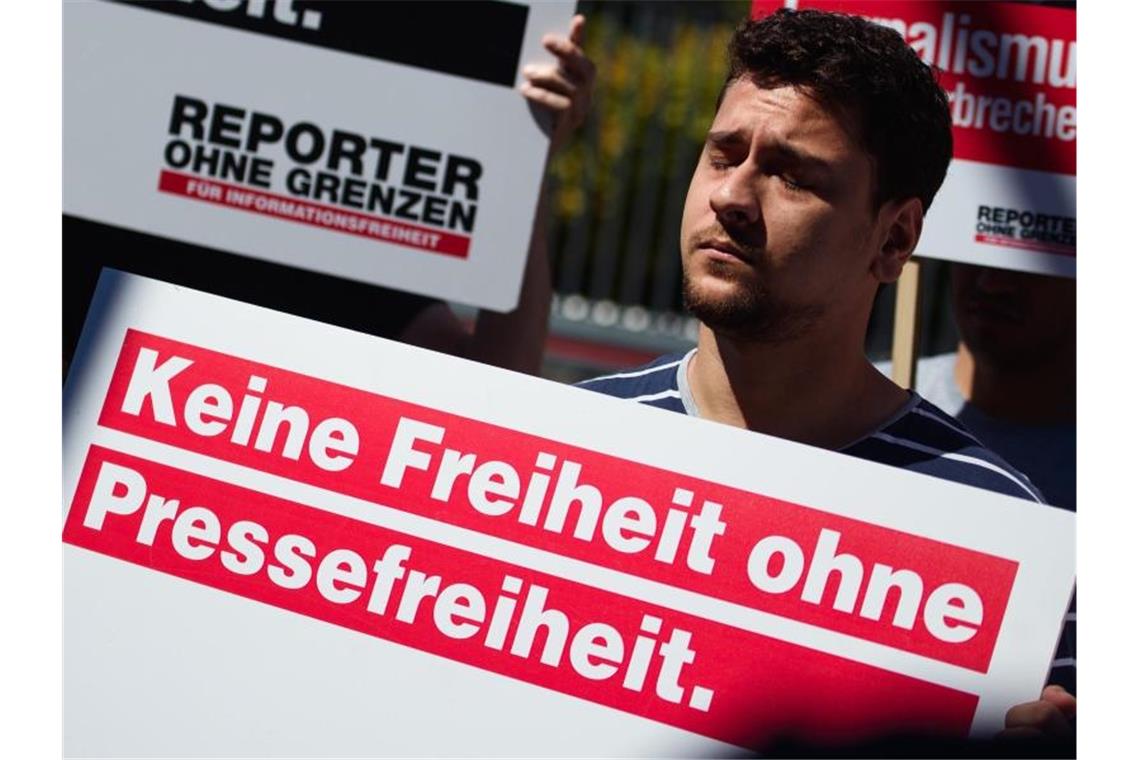Mitarbeiter und Aktivisten von Reporter ohne Grenzen während einer Protestaktion. Foto: Gregor Fischer/dpa
