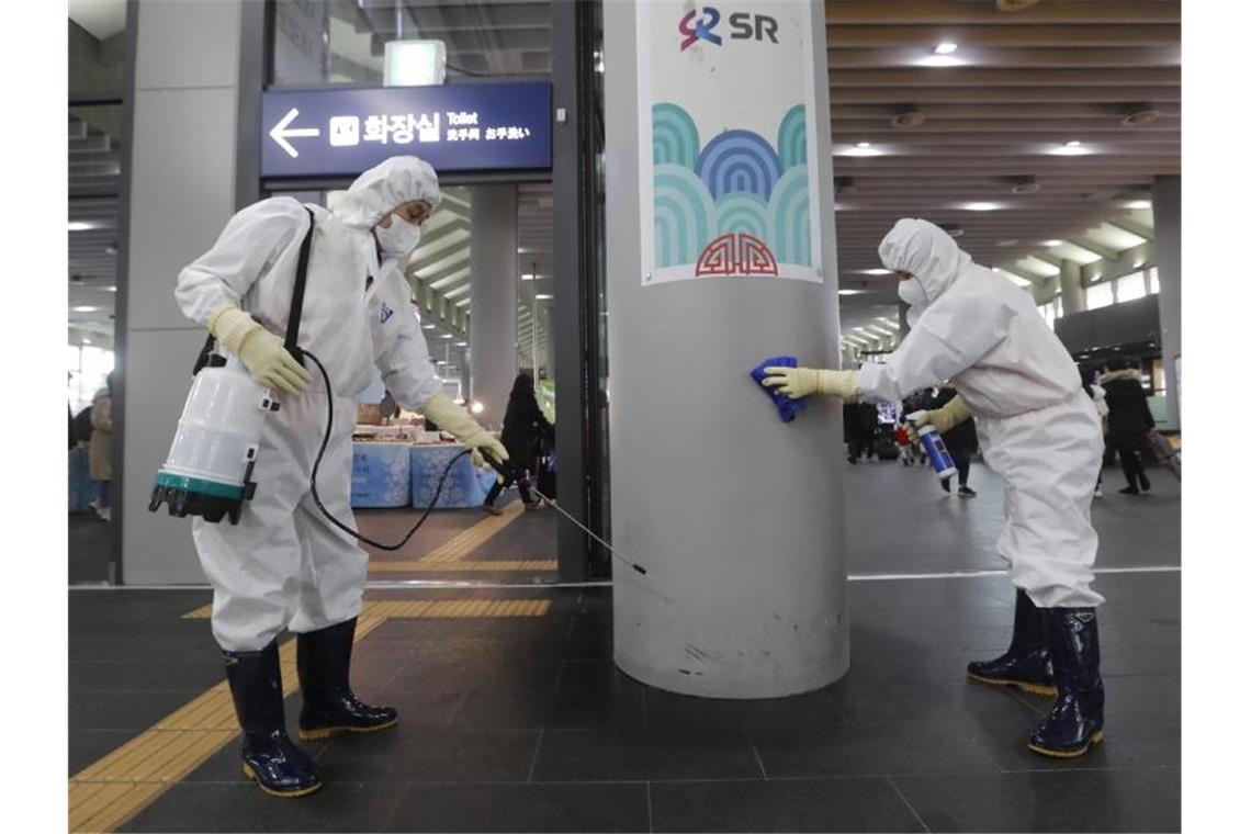 Mitarbeiter versprühen in einem Bahnhof in Seoul vorsorglich ein Desinfektionsmittel. Foto: Ahn Young-Joon/AP/dpa