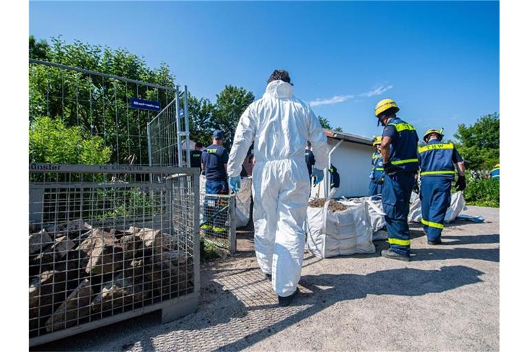 Mitarbeiter vom Technischen Hilfswerk (THW) tragen vor dem Abriss der Gartenlaube des Verdächtigen im Missbrauchsfall von Münster einen steinumrandeten Erdhügel ab. Foto: Guido Kirchner/dpa
