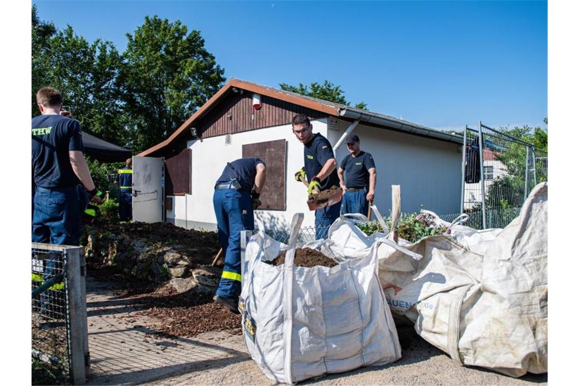 Mitarbeiter vom Technischen Hilfswerk (THW) tragen vor dem Abriss der Gartenlaube des Verdächtigen im Missbrauchsfall von Münster mit Schaufeln einen Erdhügel ab. Foto: Guido Kirchner/dpa