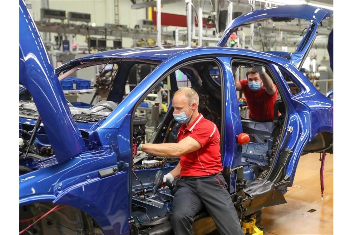 Porsche verlängert Beschäftigungssicherung Mitarbeiter von Porsche arbeiten in der Montage an einem Porsche Macan. Foto: Jan Woitas/dpa-Zentralbild/dpa