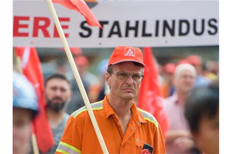 Mitarbeiter von Saarstahl stehen während einer Kundgebung auf dem Gelände von Saarstahl in Völklingen (Saarland). Foto: Oliver Dietze/dpa