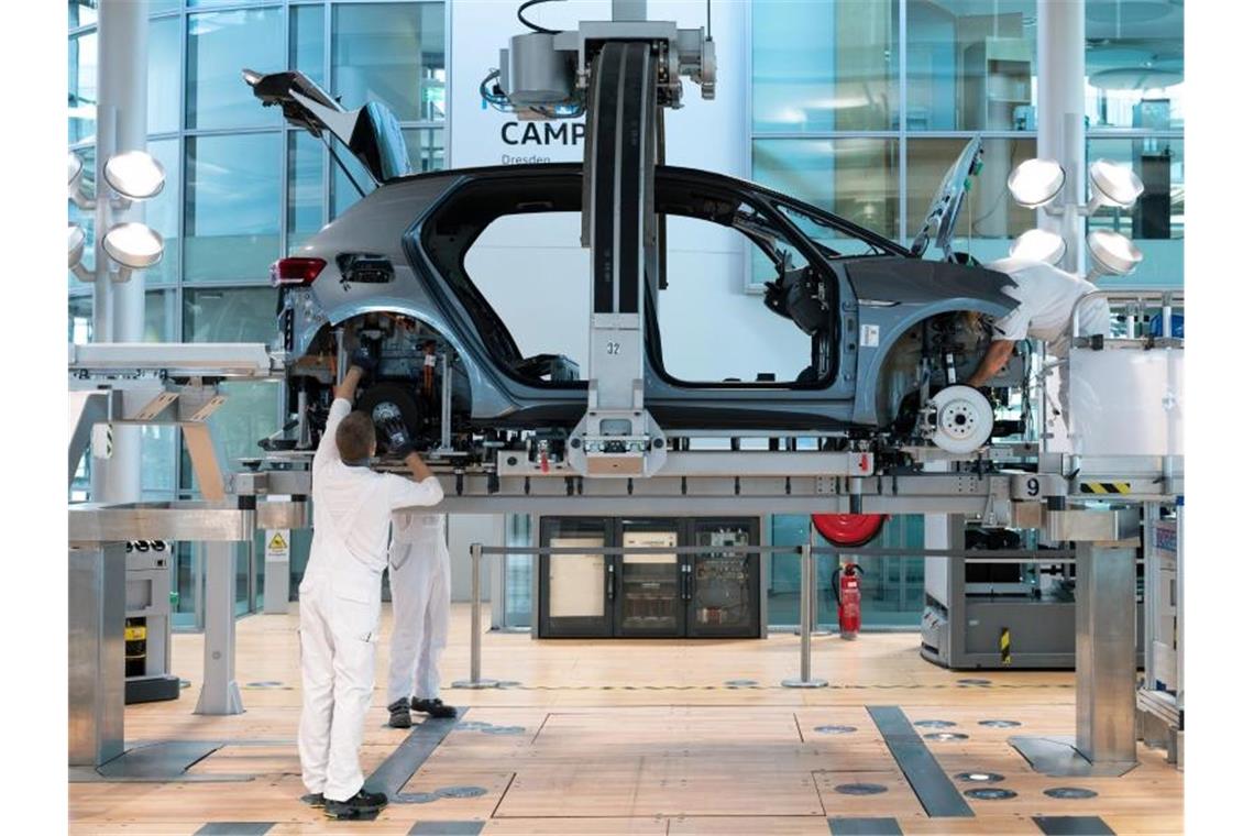 Chipmangel bremst weiterhin den deutschen Markt für Neuwagen Mitarbeiter von Volkswagen montieren in der Gläsernen Manufaktur von Volkswagen bei der sogenannten „Hochzeit“ die Karosserie und den Antriebsstrang eines VW ID.3. Foto: Sebastian Kahnert/dpa-Zentralbild/dpa