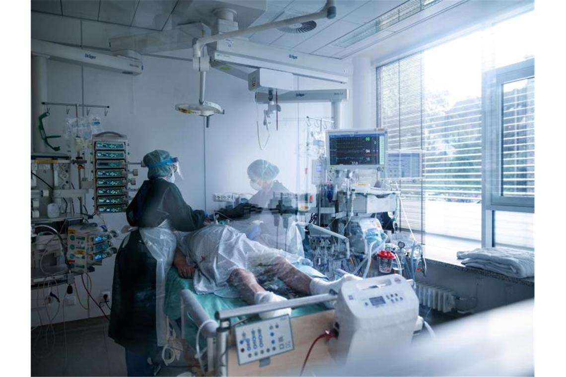 Verband warnt vor weltweitem Pflegenotstand Mitarbeiterinnen der Pflege in Schutzausrüstung betreuen einen Corona-Patienten. Foto: Fabian Strauch/dpa