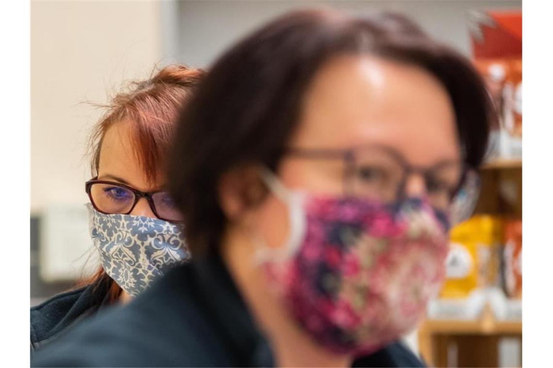 Mitarbeiterinnen eines Supermarkts mit Schutzmasken. Foto: Robert Michael/dpa-Zentralbild/dpa