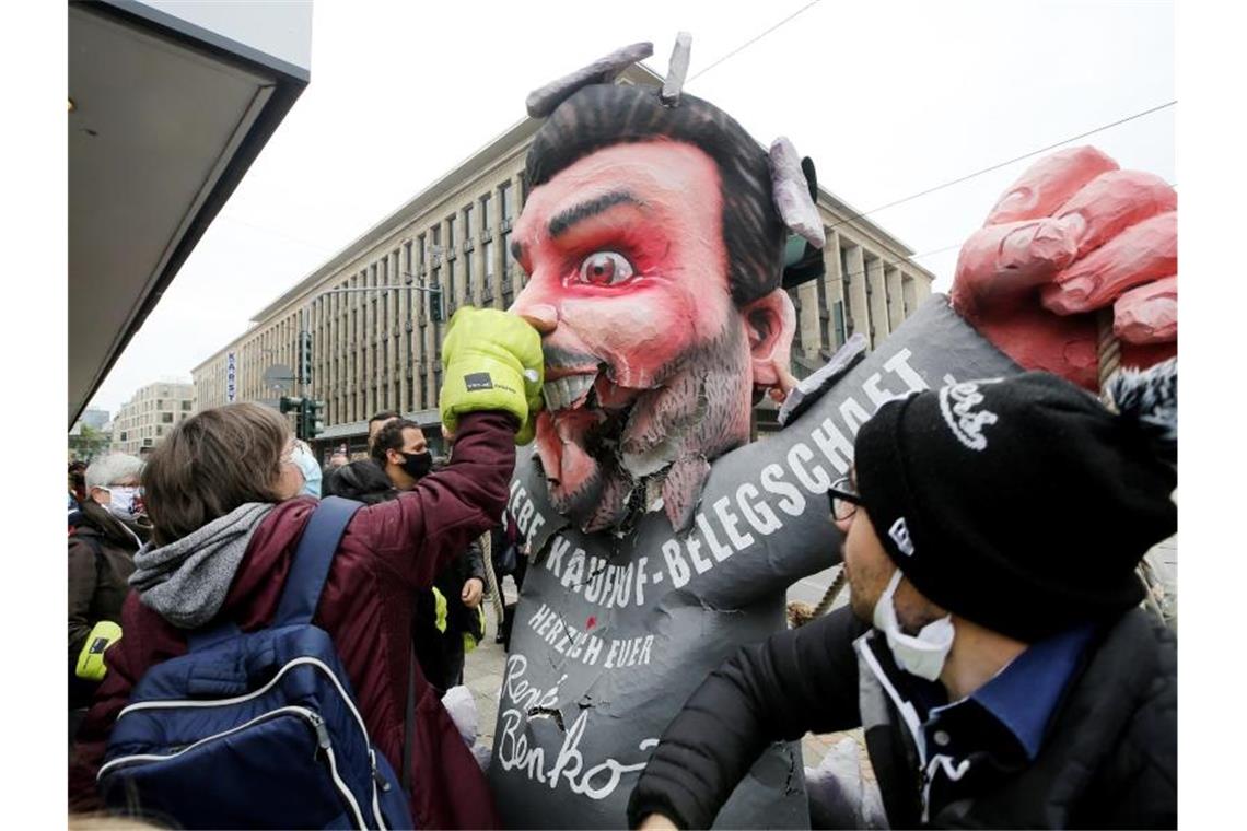 Mitarbeiterinnen und Mitarbeiter von Galeria Kaufhof schlagen am Tag der Schließung ihrer Filiale mit Boxhandschuhen auf eine Pappfigur von Firmeneigner Rene Benko ein. Foto: Roland Weihrauch/dpa