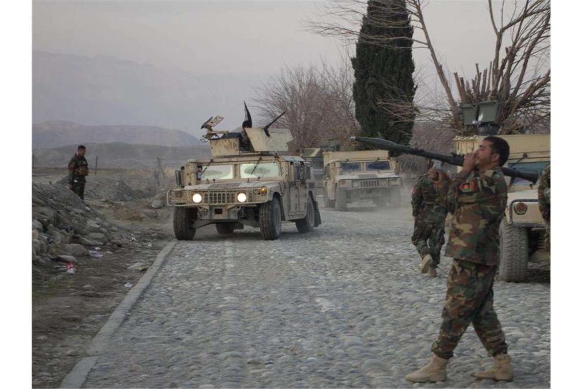 Mitglieder der afghanischen Sicherheitskräfte stehen am Ort eines Anschlages mit einer Autobombe nahe Nangarhar. Foto: Saifurahman Safi/Xinhua/dpa