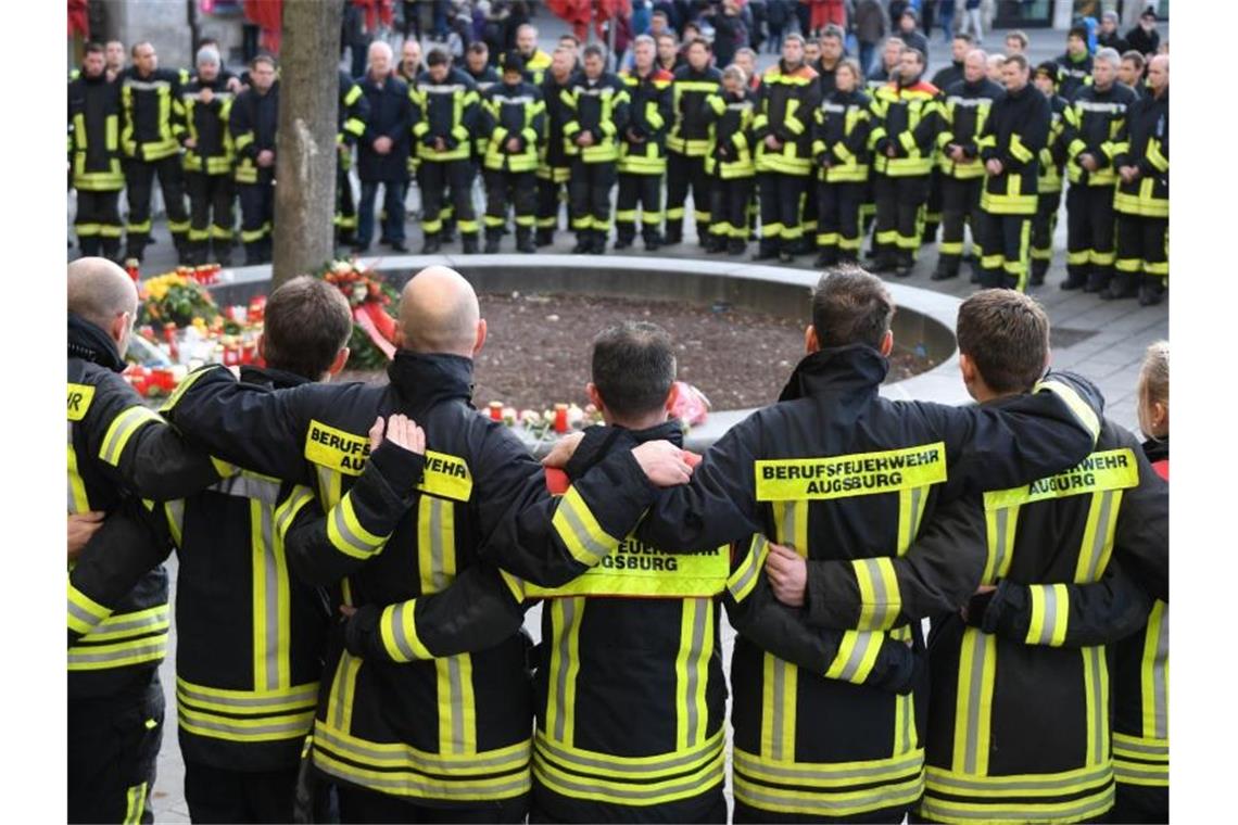 Mitglieder der Berufsfeuerwehr trauern nach der Gewalttat am Königsplatz in Augsburg. Foto: Stefan Puchner/dpa/Archiv