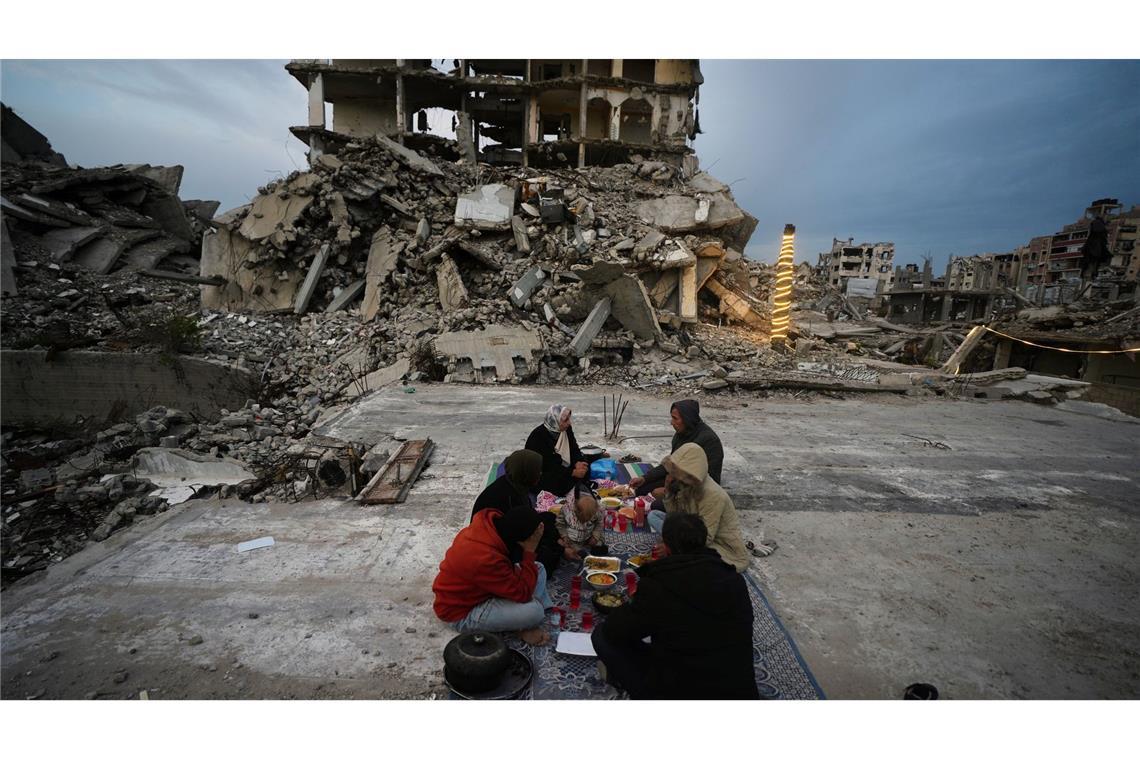Mitglieder der Familie Al-Najar brechen ihr Fasten während des muslimischen heiligen Monats Ramadan inmitten der Trümmer zerstörter Gebäude im Gazastreifen.