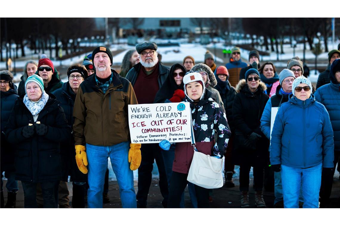 Mitglieder der Gemeinde stehen während einer Mahnwache zu Ehren einer Frau, die von einem ICE-Beamten in Minneapolis erschossen wurde, vor dem Minnesota State Capitol zusammen.