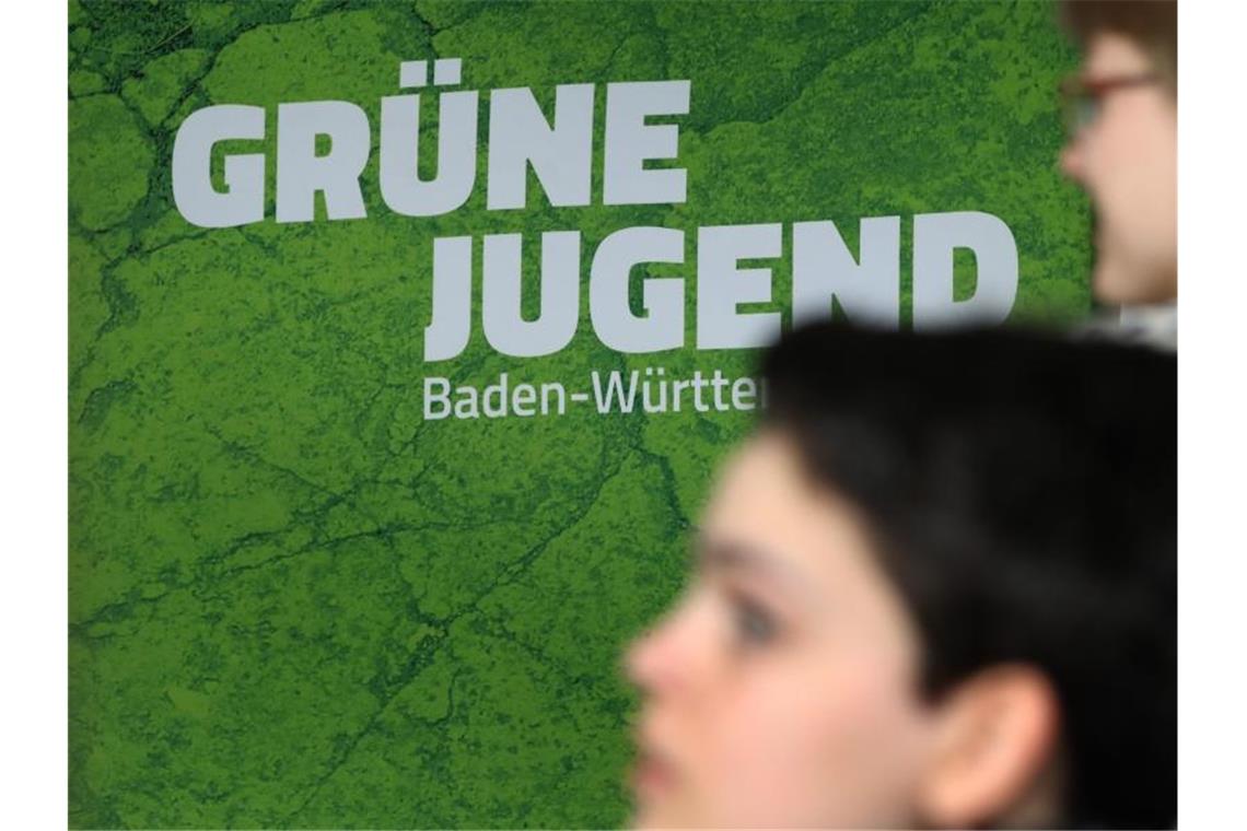 Mitglieder der Grünen Jugend Baden-Württemberg stehen bei ihrer Landesmitgliederversammlung vor dem Logo ihrer Partei. Foto: Karl-Josef Hildenbrand/dpa/Archivbild