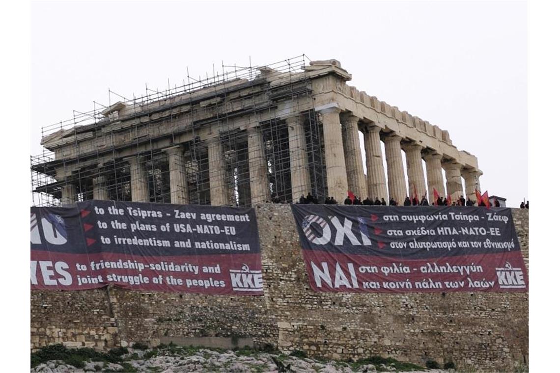 Athen einigt sich mit Mazedonien Mitglieder der Kommunistischen Partei Griechenlands stehen auf dem Akropolishügel mit riesigen Transparenten gegen das Mazedonien-Abkommen. Foto: Petros Giannakouris/AP