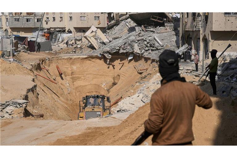 Mitglieder der militanten Hamas-Gruppe graben nach den Leichen israelischer Geiseln inmitten zerstörter Gebäude im südlichen Gazastreifen.