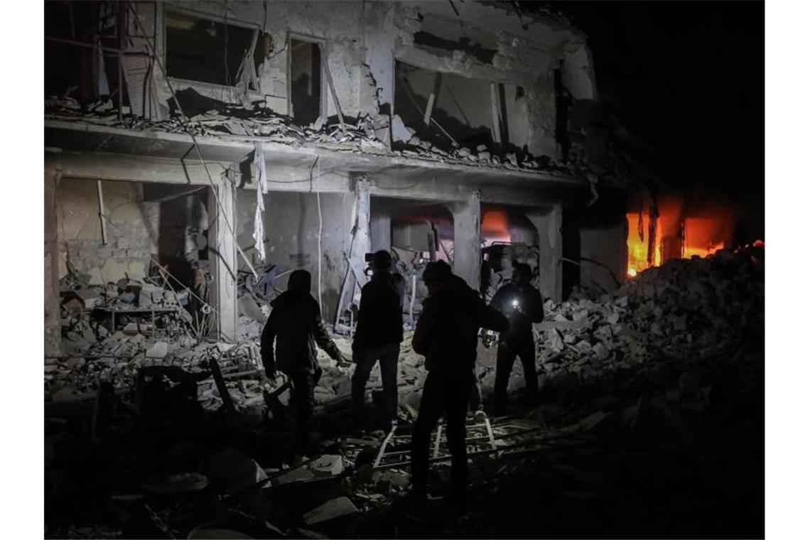 Luftangriffe auf syrisches Rebellengebiet: Klinik getroffen Mitglieder des syrischen Zivilschutzes begutachten nach einem Luftangriff Trümmer in der Stadt Ariha. Foto: Anas Alkharboutli/dpa