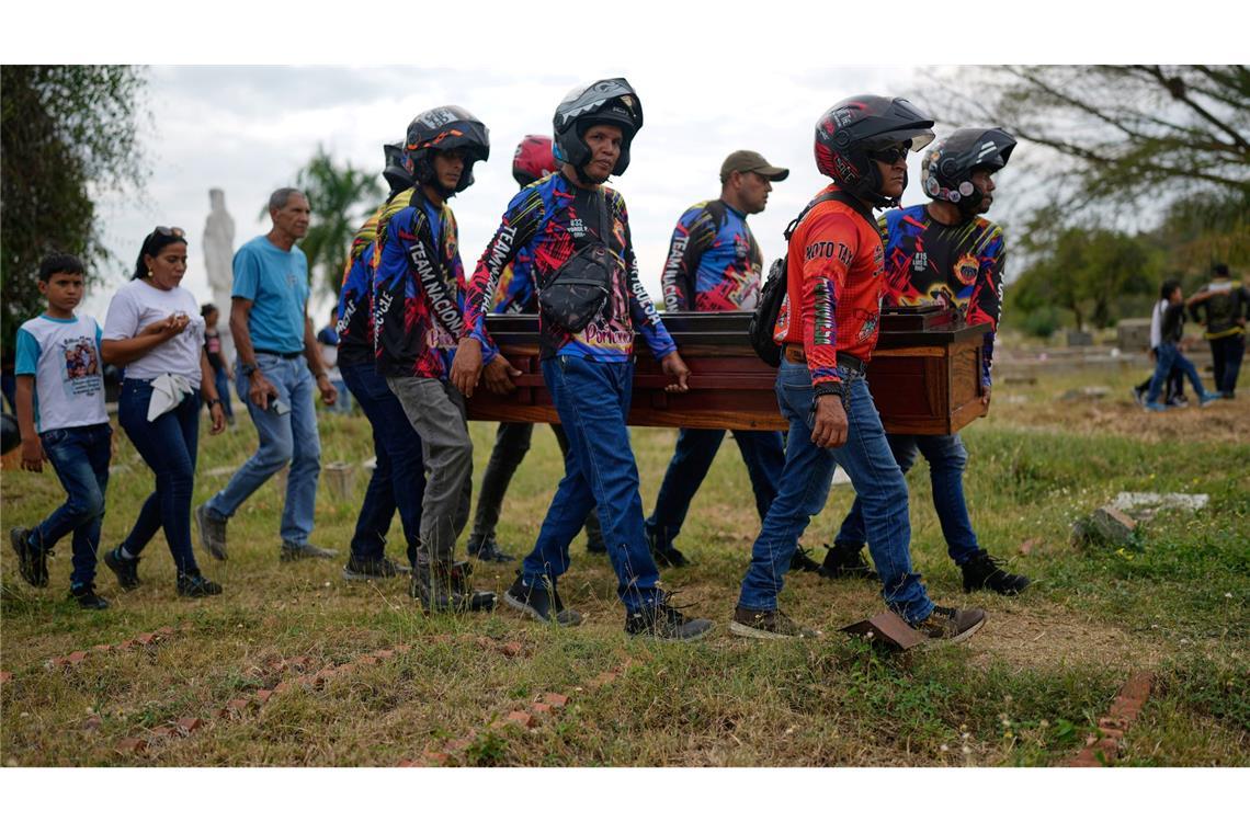 Mitglieder eines Motorradclubs und Freunde tragen den Sarg eines venezolanischen Polizisten.