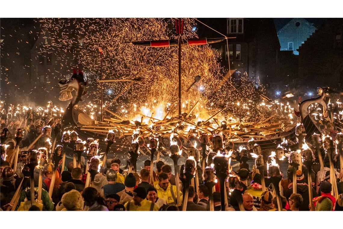 Mitglieder vom Jarl Squad zünden eine Galeere in Lerwick auf den Shetlandinseln während des Up Helly Aa-Festivals an.