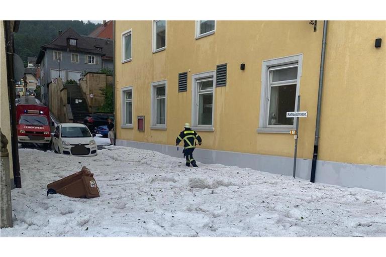 Mitten im Sommer stapft ein Feuerwehrmann durch tiefen Schnee.