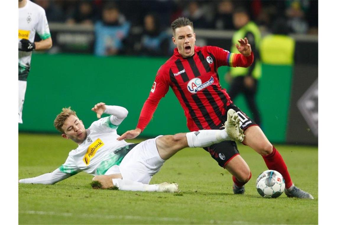 Embolo schießt Gladbach an die Spitze: 4:2 gegen Freiburg Mönchengladbachs Christoph Kramer und Freiburgs Christian Günter (l-r.) im Duell um den Ball. Foto: Roland Weihrauch/dpa