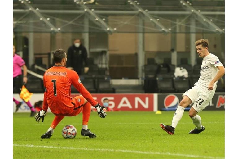 Mönchengladbachs Jonas Hofmann (r) tunnelt Inters Torwart Handanovic und erzielt das 2:1. Borussia Mönchengladbach trifft im nächsten Gruppenspiel auf Real Madrid. Foto: Cezaro de Luca/dpa