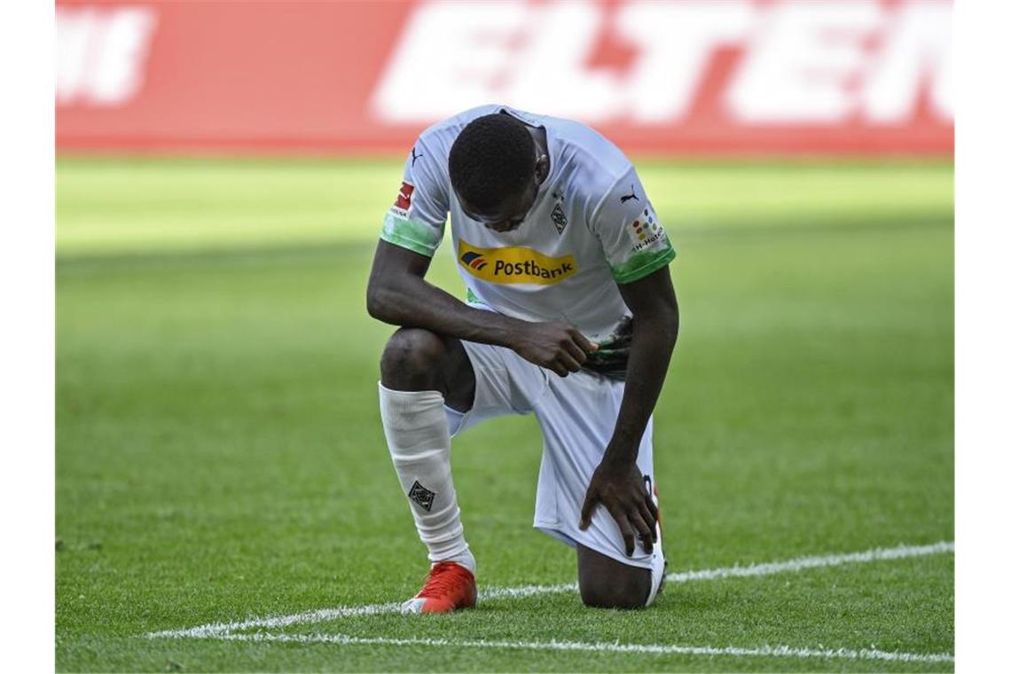 Mönchengladbachs Marcus Thuram kniete nach seinem Tor zum 2:0 gegen Union auf dem Rasen. Foto: Martin Meissner/AP Pool/dpa