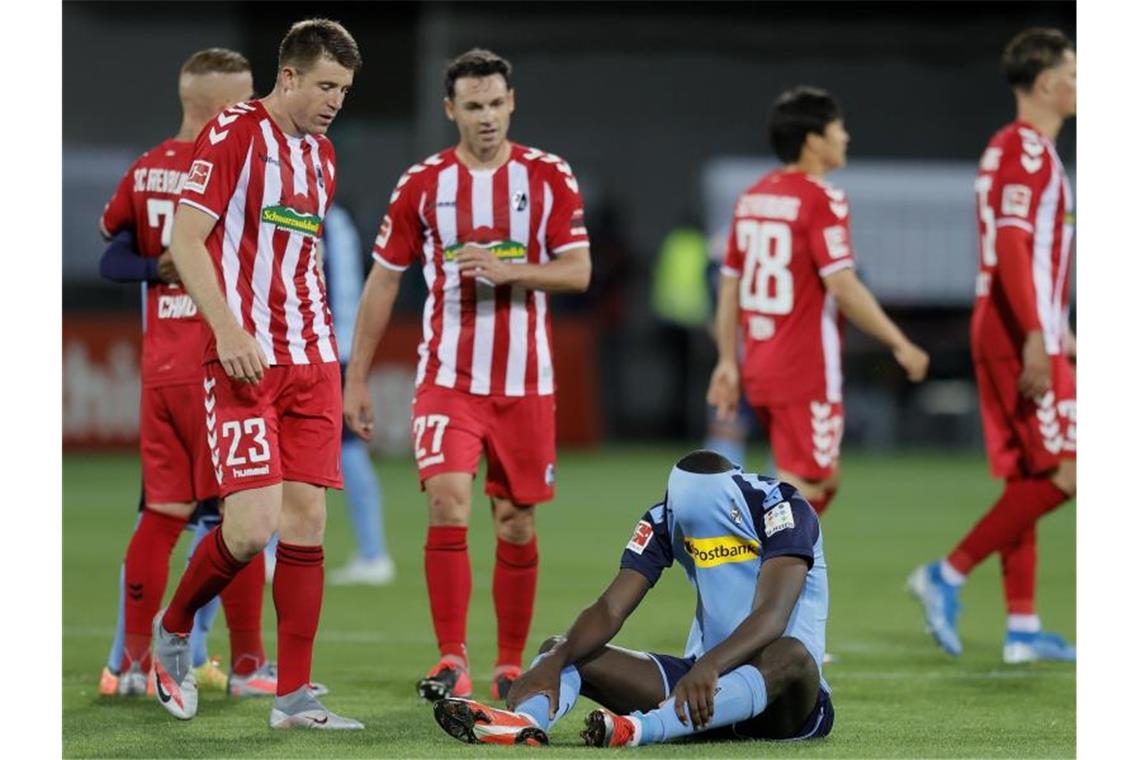 Mönchengladbachs Marcus Thuram sitzt nach der Niederlage in Freiburg enttäuscht auf dem Rasen. Foto: Ronald Wittek/epa/Pool/dpa