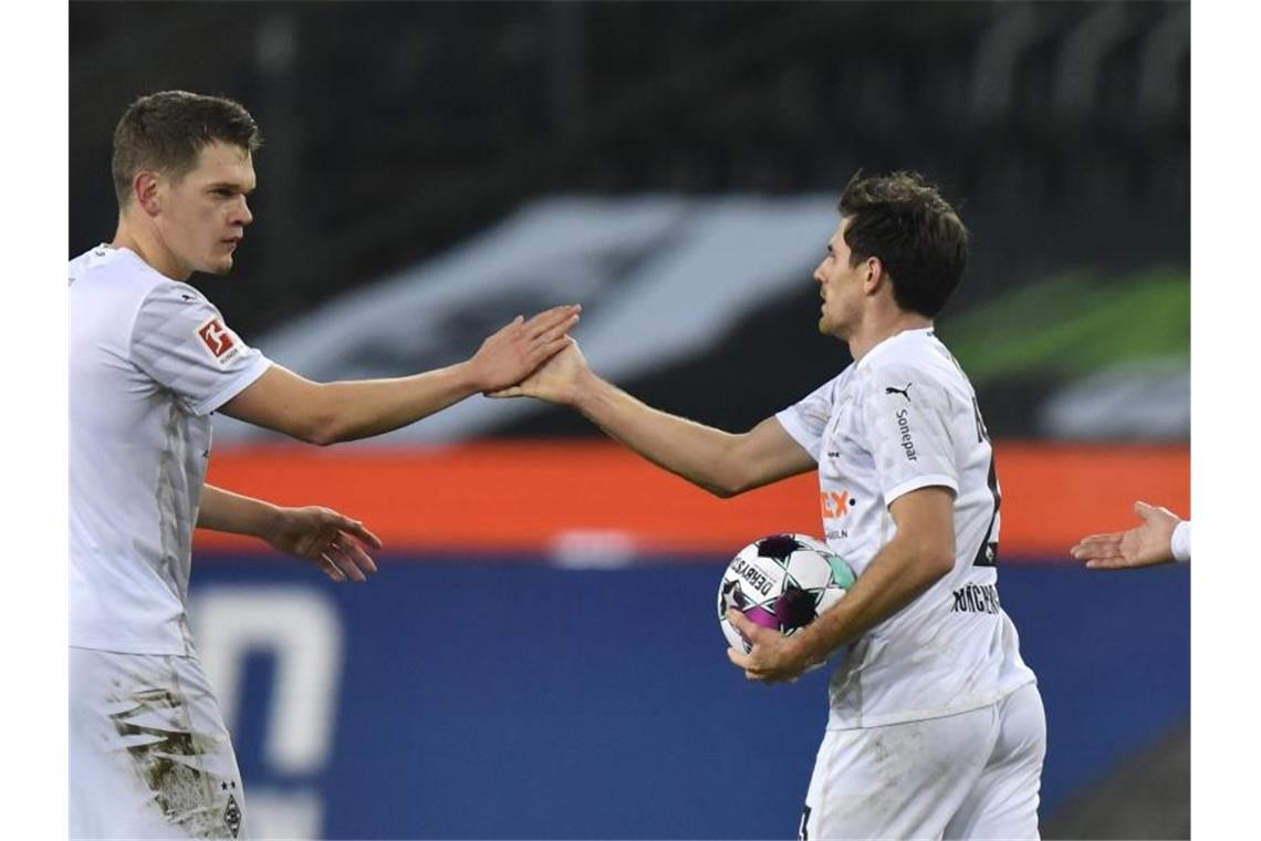 Mönchengladbachs Matchwinner Jonas Hofmann (r) und sein Mitspieler Matthias Ginter jubeln. Foto: Martin Meissner/AP/Pool/dpa