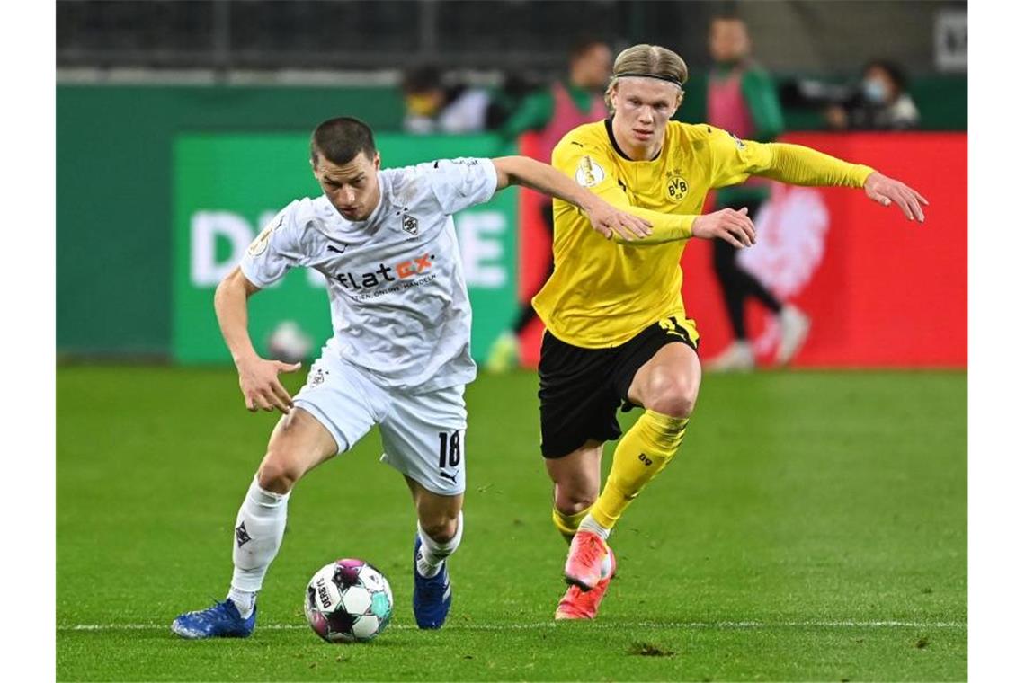 Mönchengladbachs Stefan Lainer (l) und Erling Haaland vom BVB kämpfen um den Ball. Foto: Federico Gambarini/dpa-Pool/dpa
