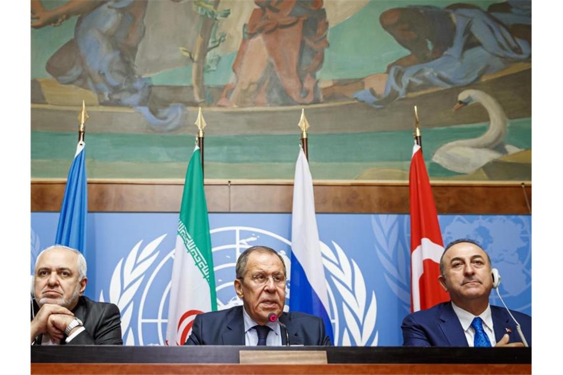Bürgerkrieg in Syrien: Verfassungsausschuss nimmt Arbeit auf Mohammed Dschawad Sarif (l-r), Außenminister des Iran, Sergei Lawrow, Außenminister von Russland, und Mevlüt Cavusoglu, Außenminister der Türkei, nehmen an einer Pressekonferenz einen Tag vor der Sitzung des syrischen Verfassungsausschusses teil. Foto: Valentin Flauraud/Keystone/AP/dpa