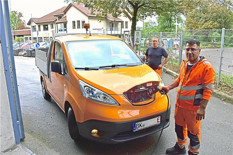 Mohammed Ismail (vorne) und Akkurt Ferhat laden ein E-Fahrzeug des Bauhofs der Stadt Backnang an der Wallbox. :Foto: Tobias Sellmaier